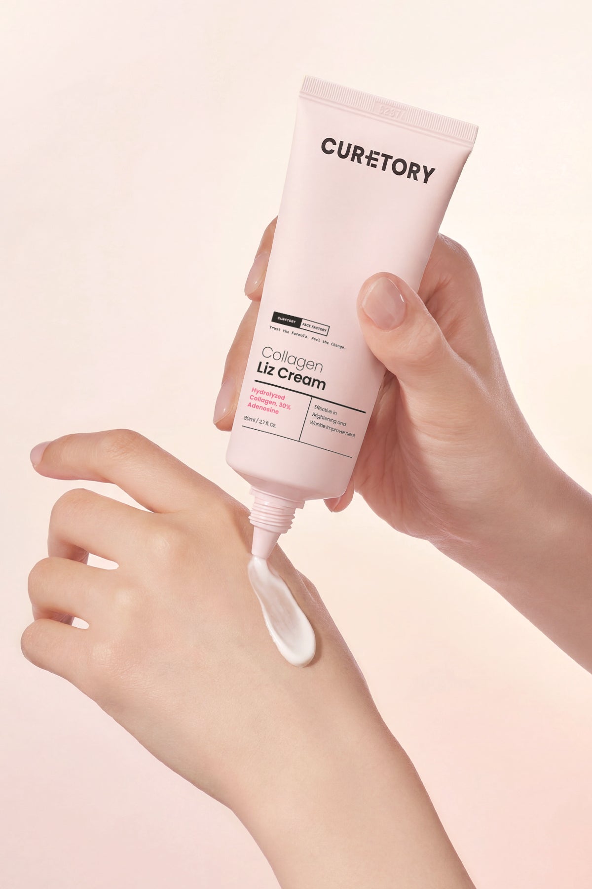 Collagen Liz Cream being applied to a hand on a light pink background
