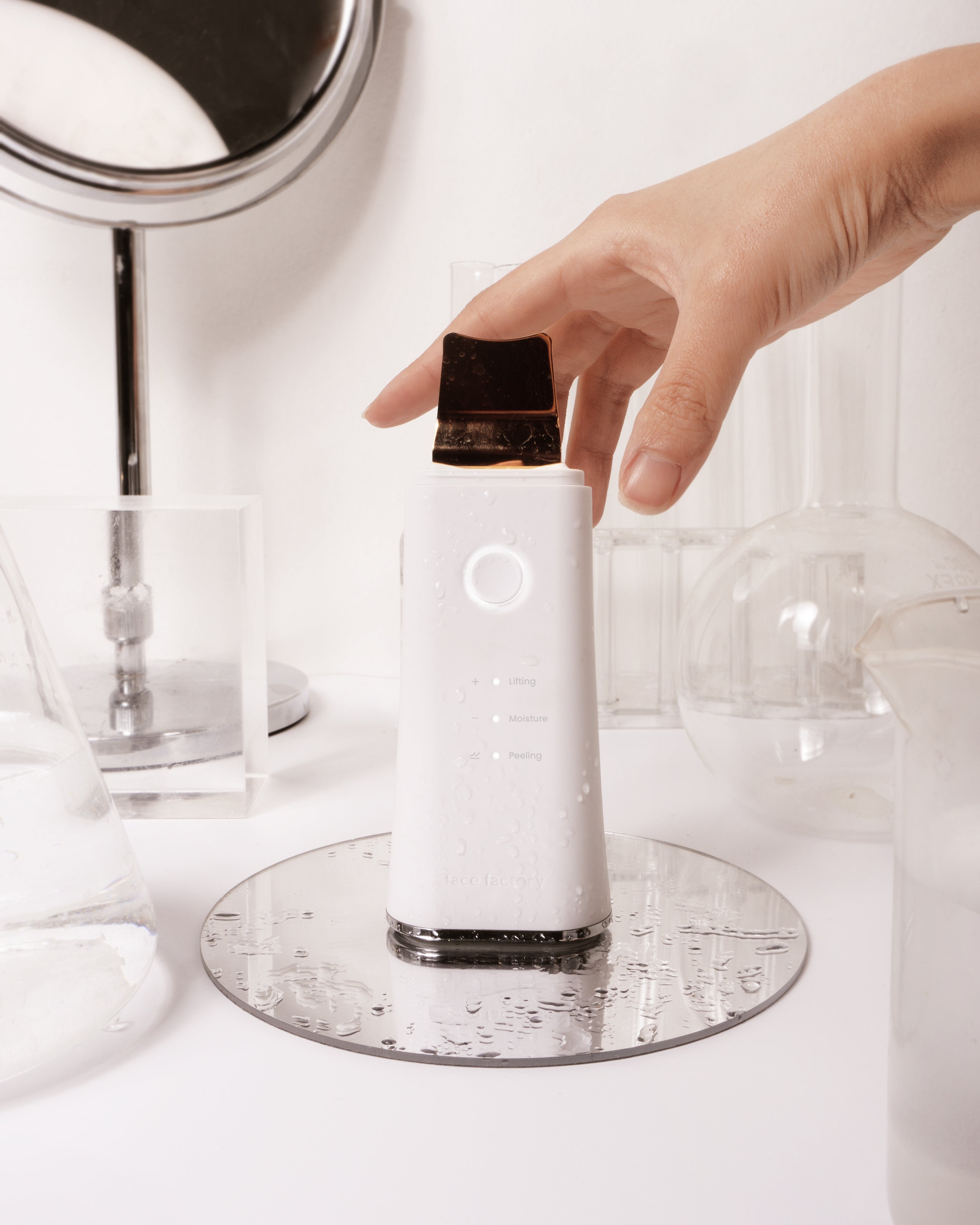 Face Factory's Galvanic Z-Water Peeling facial device with 24k gold plated spatula head in a water-based setting