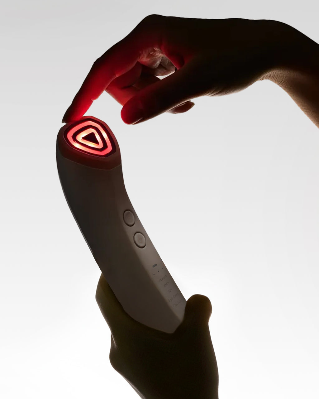 Rink Shot facial device held in hands with red LED head illuminated