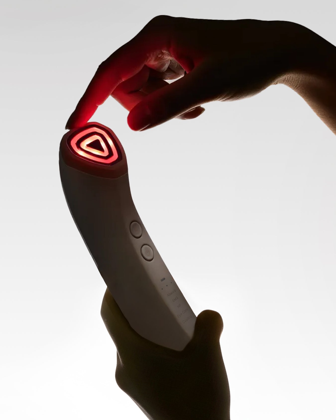 Rink Shot facial device held in hands with red LED head illuminated